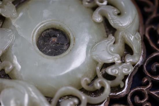 A Chinese archaistic pale celadon jade bi disc, 17th/18th century, Jade 8.3cm, frame 11cm x 12cm